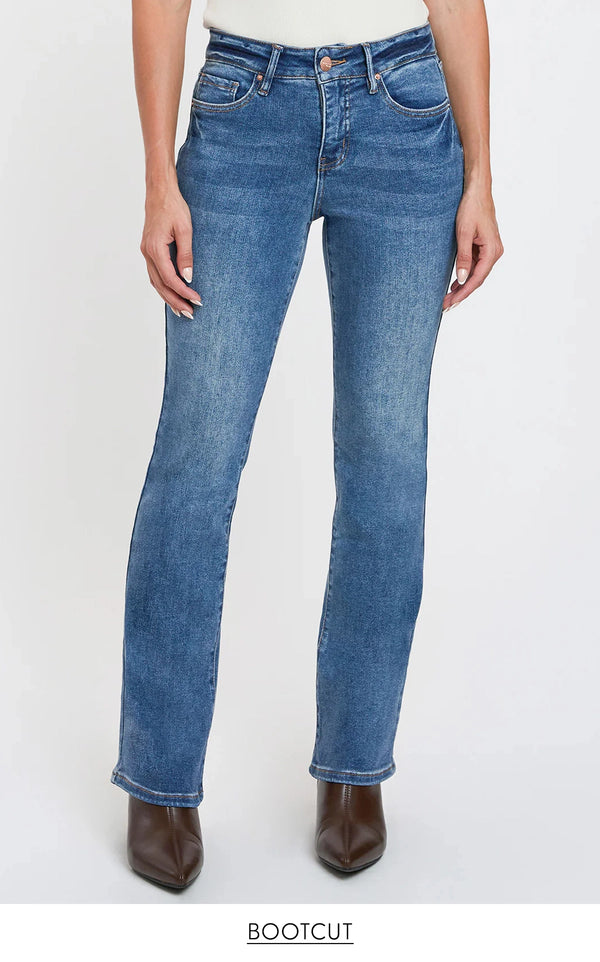 Blue bootcut jeans worn by a person on a white background