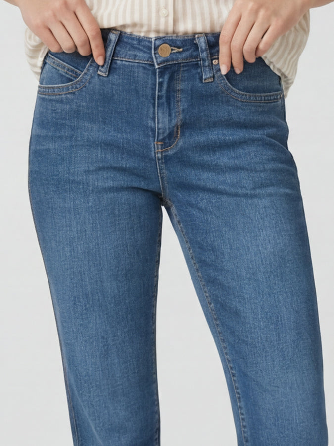 Blue jeans worn by a person on a plain background